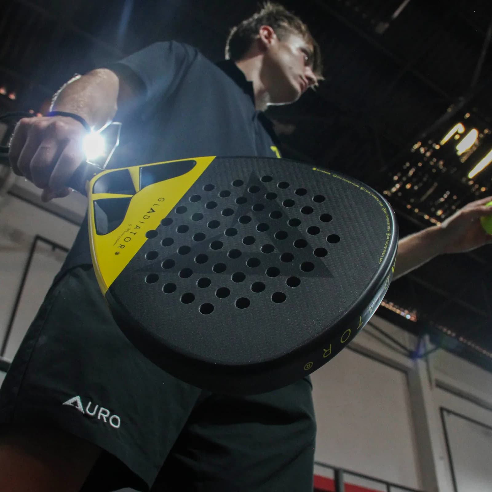A player about to serve with the Auro Gladiator on an indoor court